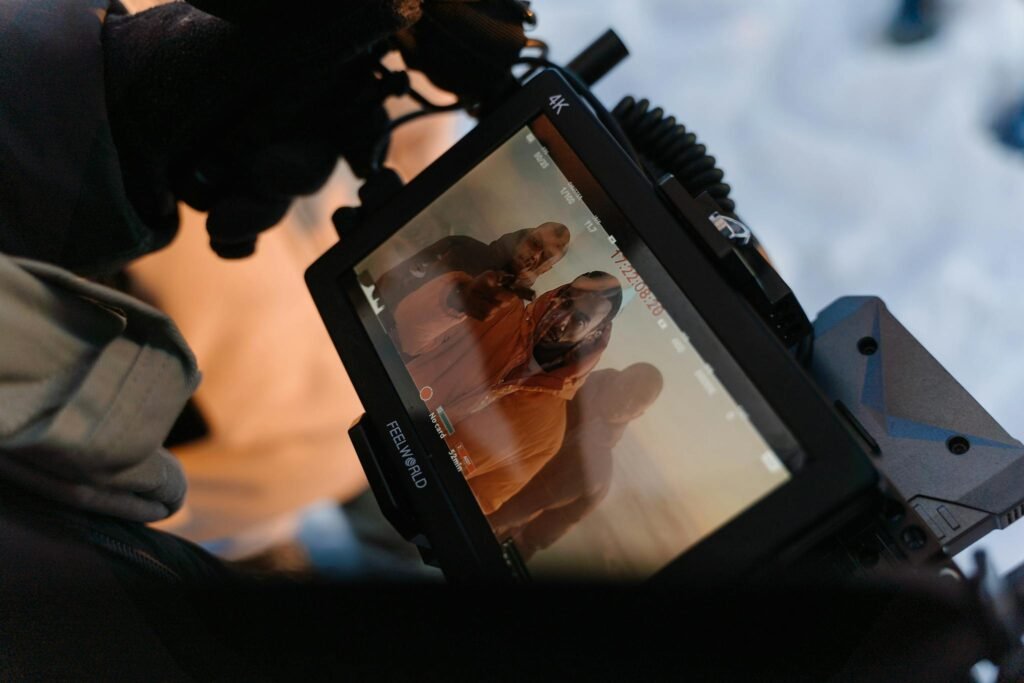 A photographer captures models on screen during a winter outdoor photoshoot.